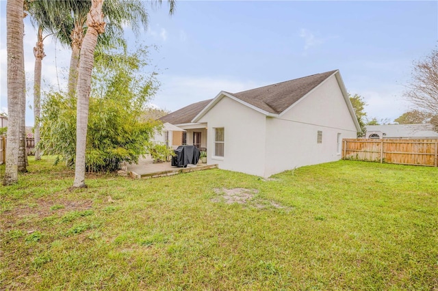 back of house featuring a patio, a yard, fence, and stucco siding