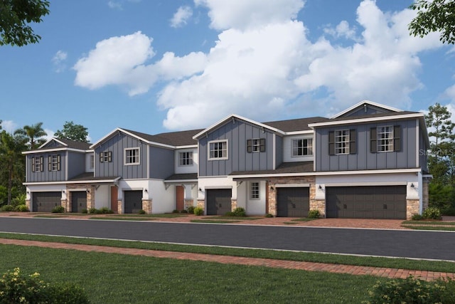 view of front of home featuring board and batten siding, a garage, stone siding, driveway, and a front lawn