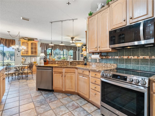 kitchen featuring visible vents, decorative backsplash, stainless steel appliances, light brown cabinets, and a sink