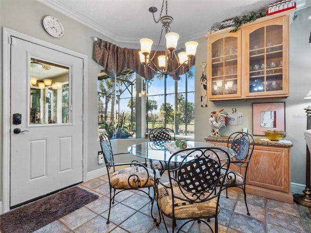 dining area featuring a chandelier, stone finish flooring, ornamental molding, and baseboards