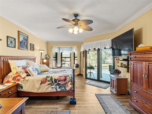 bedroom featuring light wood finished floors, ornamental molding, ceiling fan, a textured ceiling, and access to outside