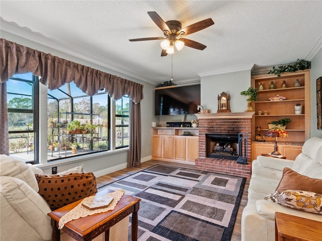 living room with a brick fireplace, plenty of natural light, ornamental molding, and wood finished floors