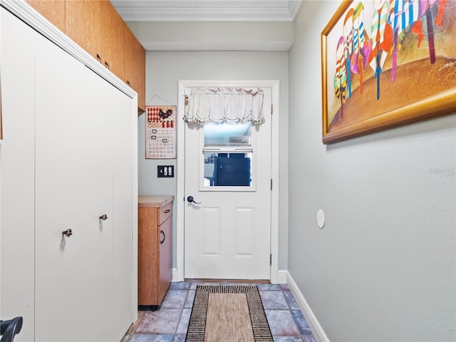 doorway to outside with ornamental molding and baseboards