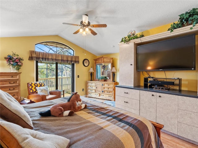 bedroom featuring access to exterior, a textured ceiling, vaulted ceiling, and light wood-style floors