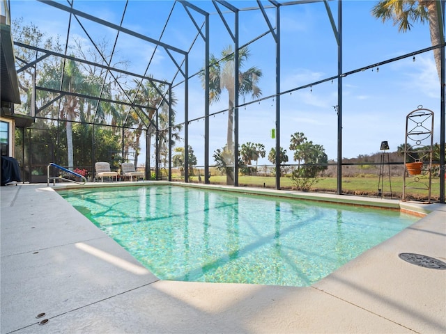 pool featuring glass enclosure and a patio