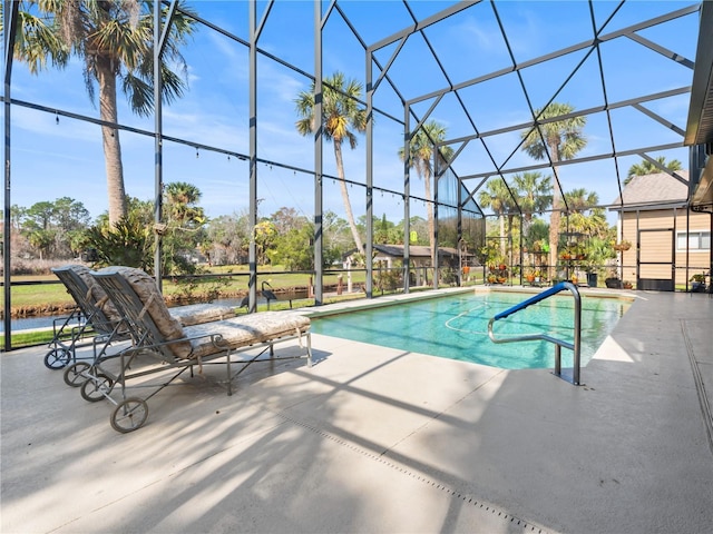 pool featuring glass enclosure and a patio area