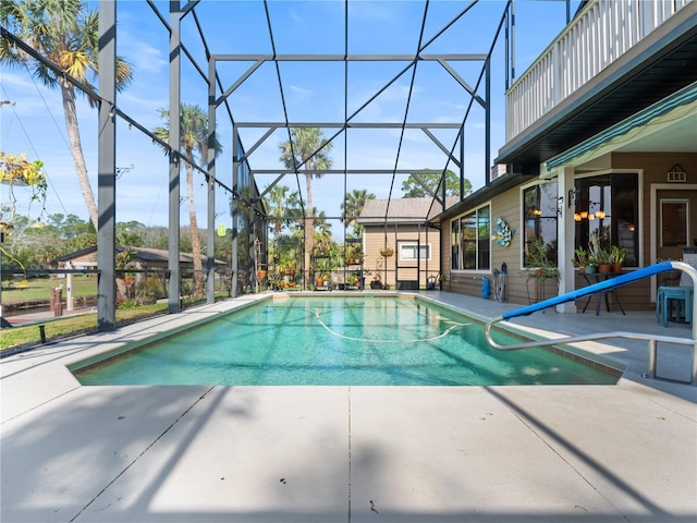 outdoor pool featuring a patio and glass enclosure