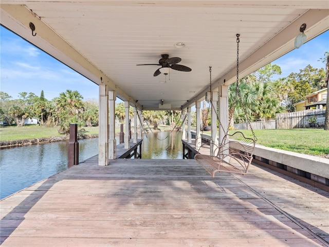 dock area featuring a yard, a water view, and fence