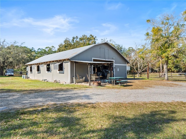 view of front facade with a front yard, a pole building, and an outbuilding