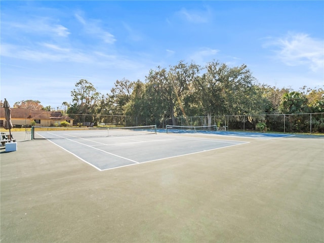 view of tennis court featuring fence