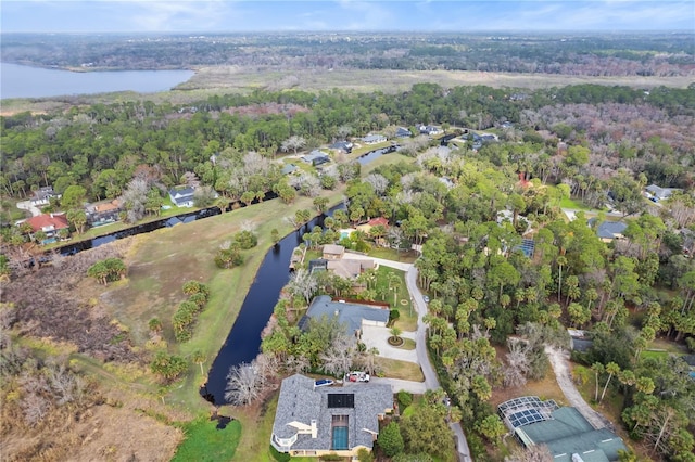 drone / aerial view featuring a water view and a forest view