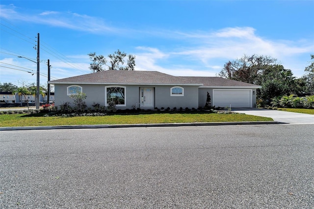 single story home with a front lawn, a garage, driveway, and stucco siding