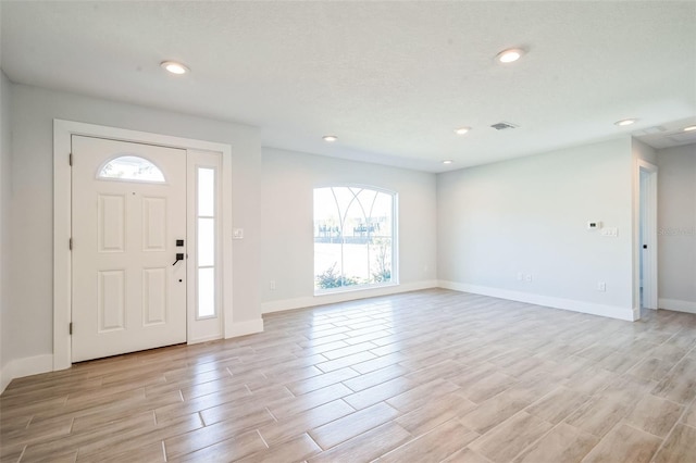 foyer featuring recessed lighting, visible vents, baseboards, and light wood-style floors