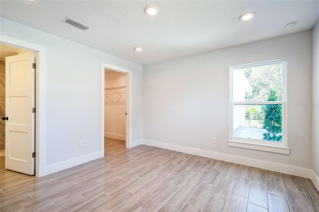 spare room with recessed lighting, visible vents, baseboards, and light wood-style flooring