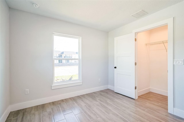 spare room featuring visible vents, baseboards, and light wood finished floors