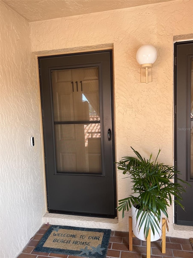 property entrance with stucco siding