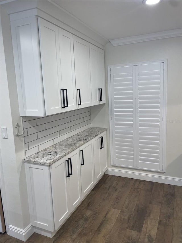 kitchen with dark wood-style flooring, white cabinets, and crown molding