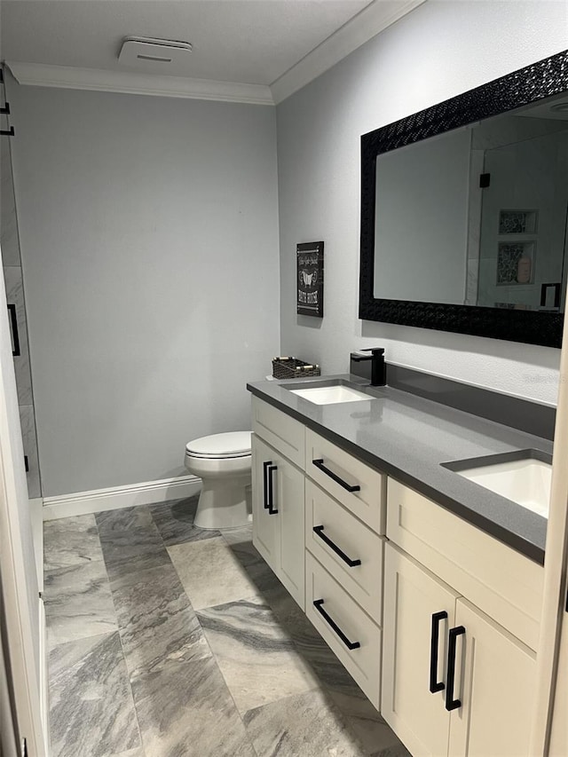 bathroom featuring double vanity, toilet, ornamental molding, a sink, and baseboards