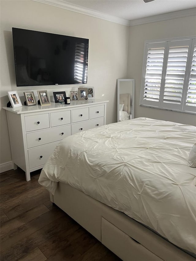 bedroom with dark wood-style flooring and crown molding