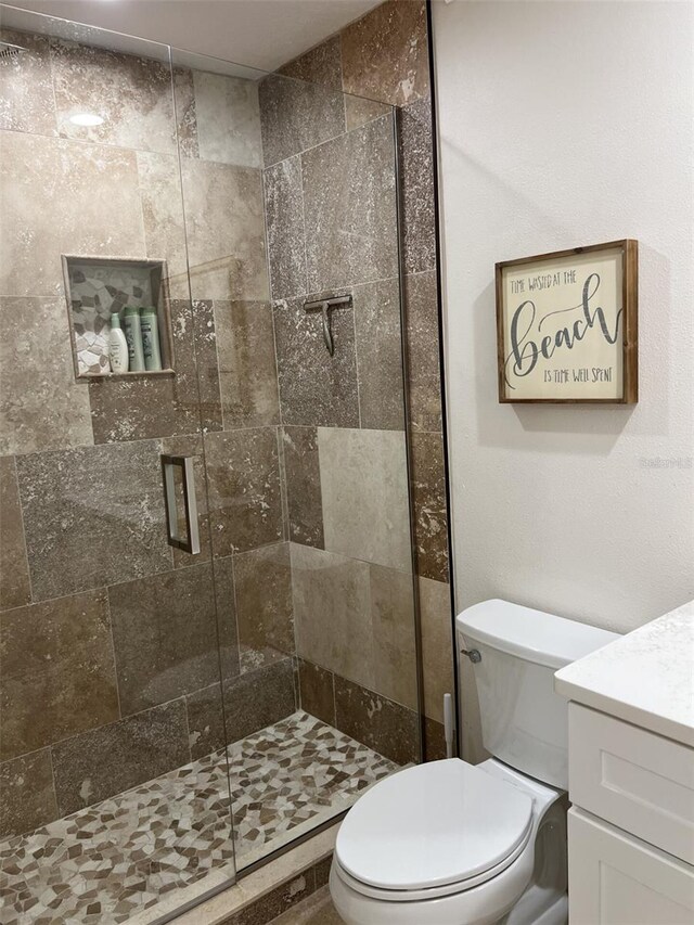 full bath featuring a stall shower, vanity, and toilet