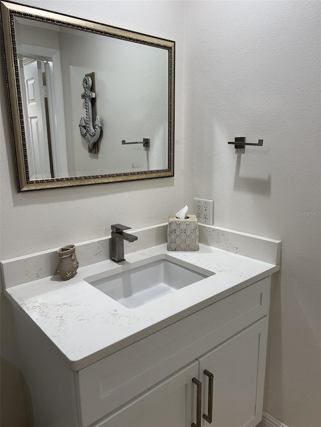 bathroom with a textured wall and vanity