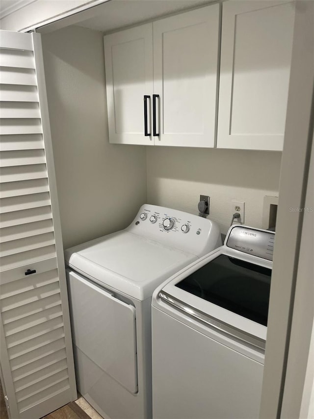 laundry room featuring separate washer and dryer and cabinet space