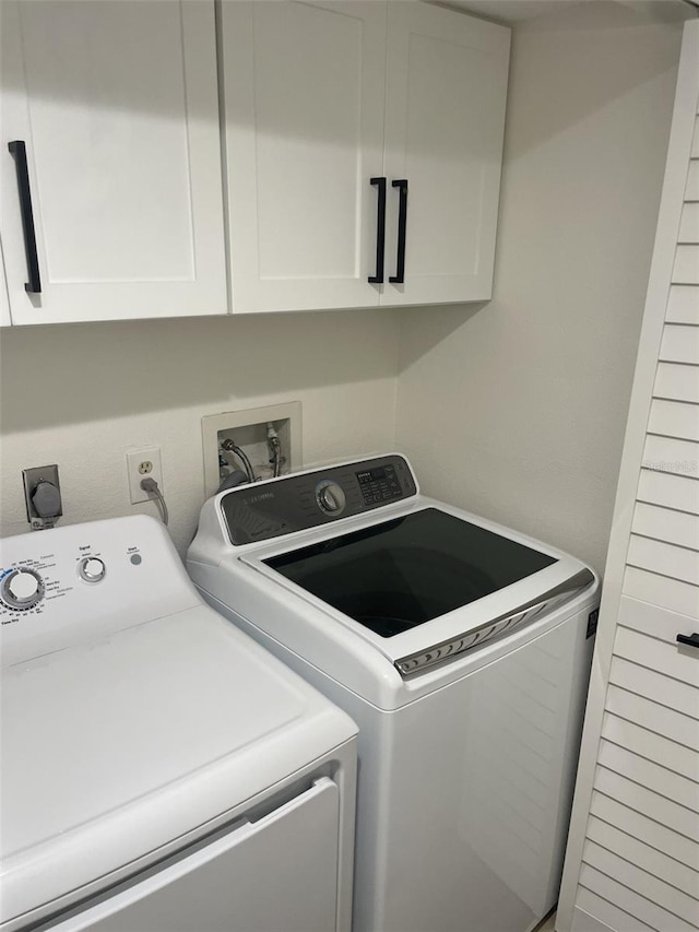 washroom with cabinet space and washer and dryer