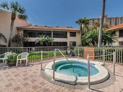 view of pool with a hot tub and fence