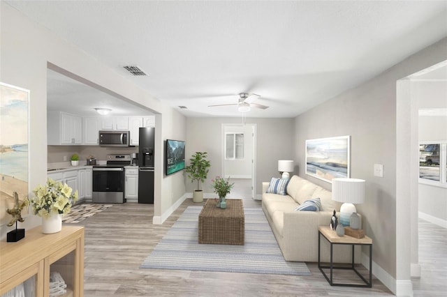 1203 S Pomegranite Ave, Sanford, FL 32771 - living area featuring light wood-style floors, a ceiling fan, and baseboards