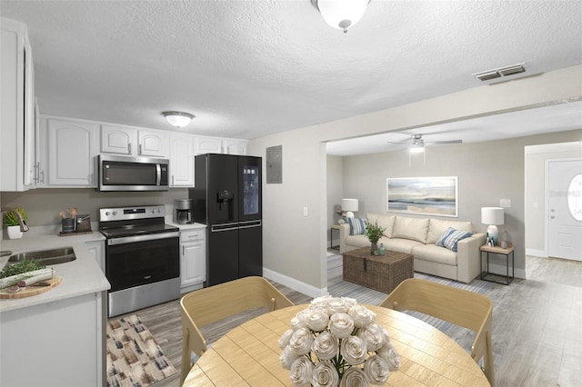 1203 S Pomegranite Ave, Sanford, FL 32771 - kitchen featuring stainless steel appliances, light wood-style flooring, a sink, visible vents, and white cabinetry