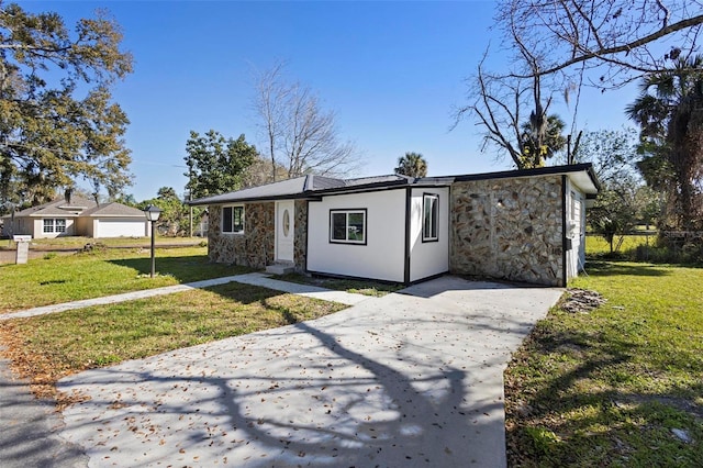 1203 S Pomegranite Ave, Sanford, FL 32771 - view of front of house with concrete driveway, a front lawn, and stone siding