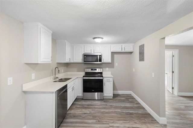 1203 S Pomegranite Ave, Sanford, FL 32771 - kitchen with white cabinets, appliances with stainless steel finishes, a sink, and light wood finished floors