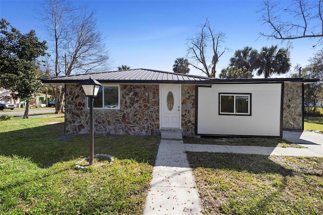 1203 S Pomegranite Ave, Sanford, FL 32771 - bungalow with a front lawn, stone siding, and metal roof