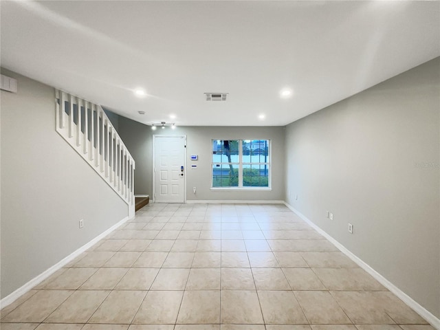 interior space with visible vents, stairway, baseboards, and light tile patterned flooring