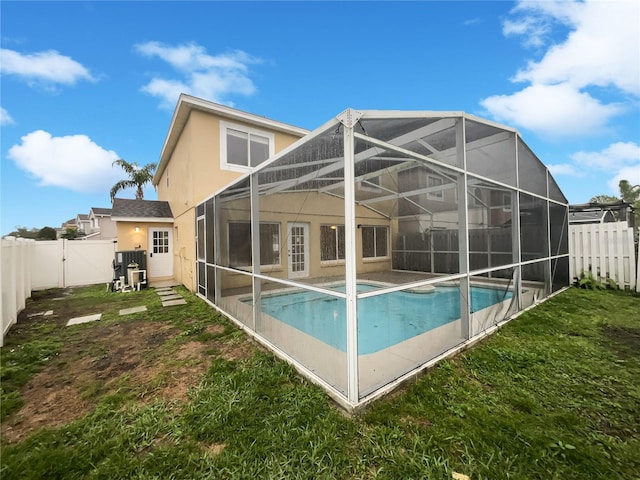 rear view of property featuring a lanai, a fenced backyard, a fenced in pool, a gate, and stucco siding