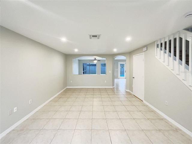 spare room with arched walkways, stairway, visible vents, and recessed lighting