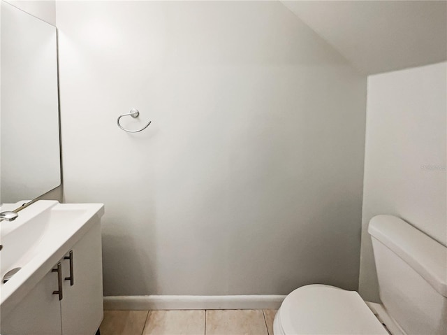 half bathroom with baseboards, toilet, and tile patterned floors