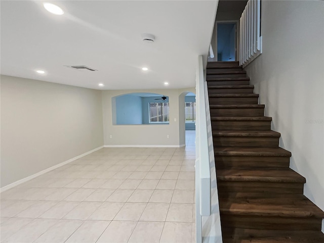 stairway featuring arched walkways, tile patterned flooring, visible vents, and recessed lighting