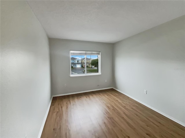 unfurnished room with wood finished floors and baseboards