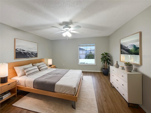 bedroom with a ceiling fan, dark wood finished floors, and a textured ceiling