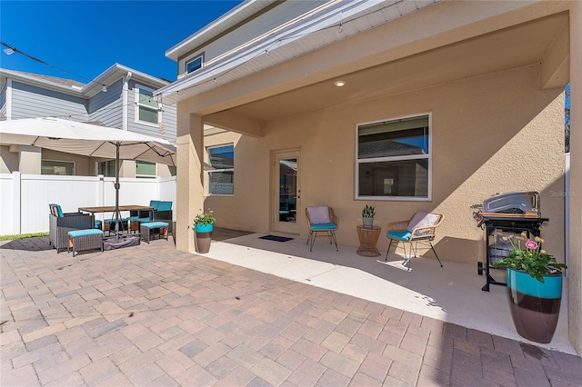 view of patio with a grill and fence