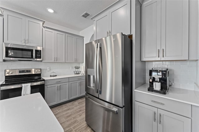 kitchen featuring stainless steel appliances, light countertops, and visible vents