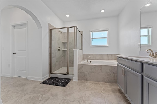 bathroom with vanity, a shower stall, a bath, and recessed lighting