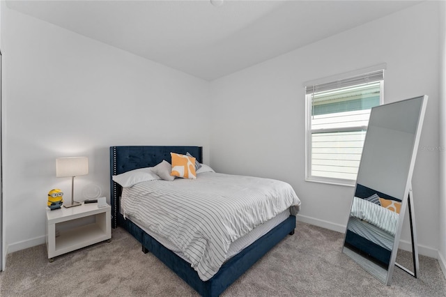 bedroom with baseboards and light colored carpet