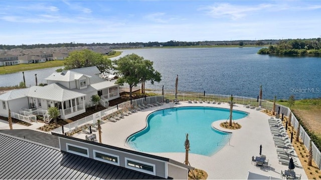 pool featuring a water view, fence, and a patio