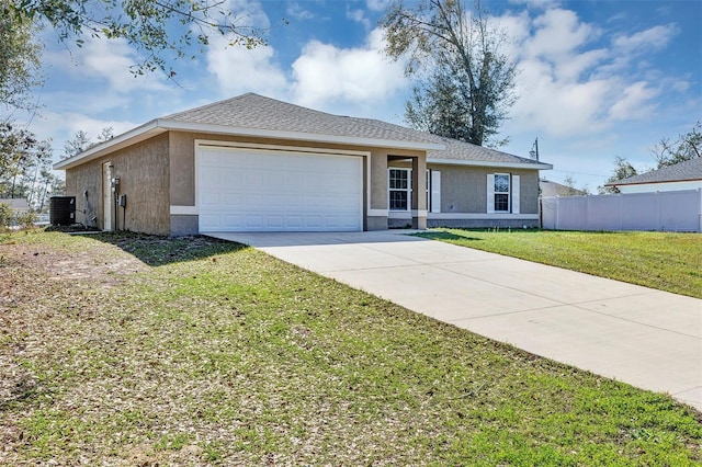 ranch-style home with an attached garage, fence, driveway, stucco siding, and a front yard