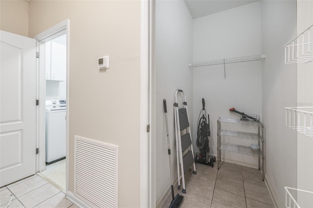 interior space with washer / clothes dryer, visible vents, cabinet space, and light tile patterned floors