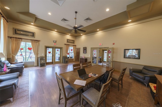 dining area featuring french doors, visible vents, ceiling fan, and a towering ceiling