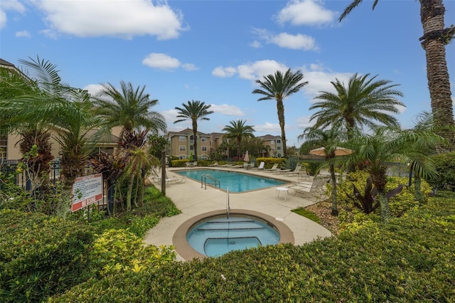 pool with a community hot tub and a patio