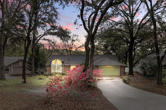 view of front of house featuring a garage, concrete driveway, and brick siding